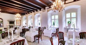 布罗斯特科克达尔斯洛茨酒店 的餐厅配有白色的桌椅和吊灯
