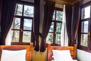 特拉布宗Şamlıoğlu Historical Villa的一间卧室设有两张床,窗户配有窗帘