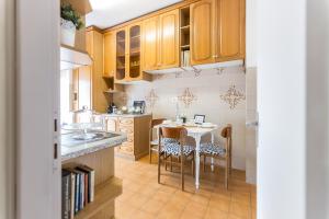 罗马Casa Giordano的厨房配有木制橱柜和桌椅