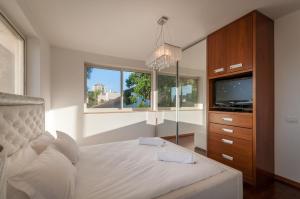 荷兹利亚Cosytal Villa的一间卧室设有一张床、一台电视和一个窗口。