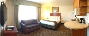瓦西拉瓦西拉阿拉斯加精品汽车旅馆的配有一张床和一把椅子的酒店客房