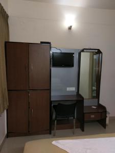 迈索尔Banyan Tree Comforts Mysore的一间卧室配有书桌、镜子和梳妆台