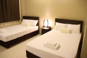 科罗尔DW汽车旅馆 的配有白色床单的酒店客房内的两张床