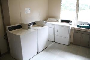 科罗尔DW汽车旅馆 的洗衣房配有白色洗衣机和烘干机