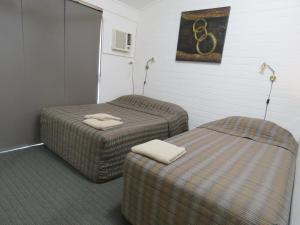 埃默拉尔德翡翠花园汽车旅馆公寓的两张带两张床的客房内的两把脚凳