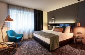 奥斯纳布吕克多梦酒店的酒店客房,配有一张床和一张蓝色椅子