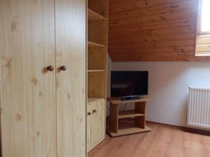 大梅杰尔Apartmany Judita Kissová的客厅配有木制橱柜和电视。