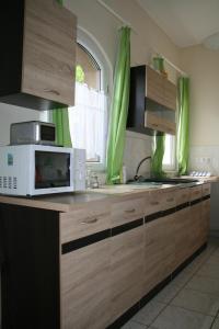 鲍洛托内瑟德Kápolnai nyaralóház的厨房配有木制橱柜和微波炉。