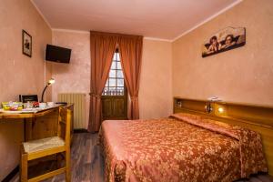 库马约尔德格拉斯尔酒店的一间卧室配有一张床、一张书桌和一个窗户。