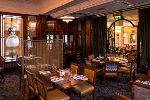 罗奇代尔皇家托比酒店的一间设有桌椅的餐厅和一个窗户上的女人