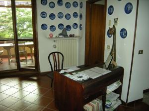 巴斯基里奥B&B Il Glicine di Basiglio的一间设有书桌的客房,墙上挂着蓝色的盘子