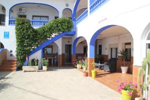 博罗尼亚米拉玛公寓酒店的蓝色和白色的建筑,有蓝色的拱门和植物