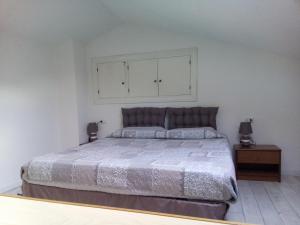 坎普码头Appartamento Scirocco的一间卧室设有一张大床和白色的墙壁