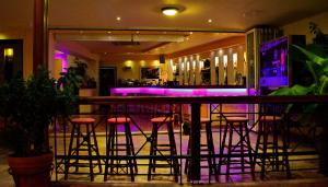 卡拉索斯卡拉托斯阳光酒店的紫色灯室里带凳子的酒吧