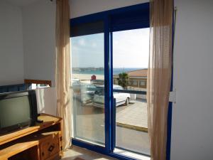 塔里法Livingtarifa Apartamento Blue II的一间房间,外面有一扇带汽车的滑动玻璃门