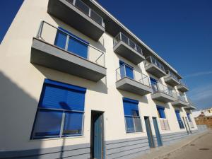 塔里法Livingtarifa Apartamento Blue II的白色的建筑,有蓝色的窗户和门