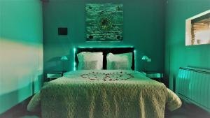 蒙特雷若马吉乐维斯宾馆的一间卧室设有一张大床和绿色的墙壁