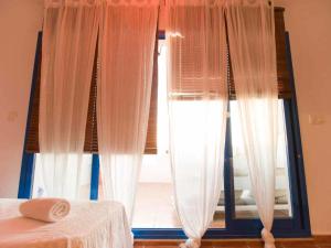 塔里法Livingtarifa Ático Altarik的一间卧室设有窗户、窗帘和一张床