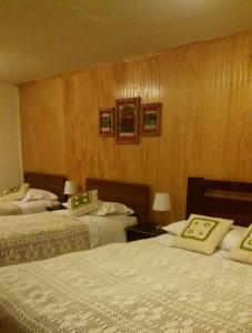 科伊艾科Apartamento Bordeluna的酒店客房,设有两张床和木墙