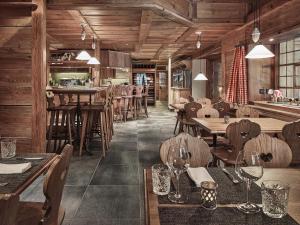 翁根舍内格酒店的餐厅铺有木地板,配有桌椅