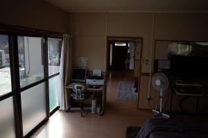 高千穗町高千穂峡贷別庄旅馆的客厅配有书桌和电视。