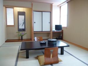 IshiokaHotel Hashimotorou的客厅配有桌子和两把椅子