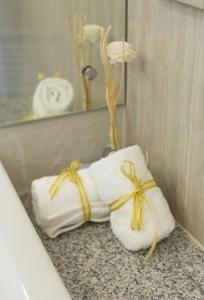Si Maha Phot304花园酒店的浴室提供2条白色毛巾和黄色蝴蝶结