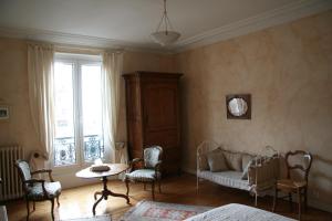 勒芒Chambres d'hôtes Le Clos d'Hauteville的卧室配有一张床和一张桌子及椅子