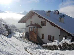 维兰德罗马尔塞特霍夫农家乐的雪 ⁇ 山上一座有雪盖屋顶的房子