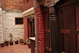 帕坦扬巴传统住宿加早餐旅馆的砖砌建筑的入口,有盆栽植物