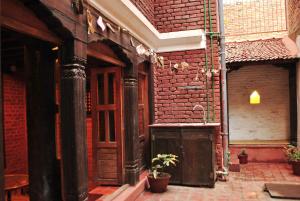 帕坦扬巴传统住宿加早餐旅馆的砖砌的建筑,木门和盆栽植物