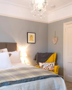 威布里治April House Weybridge - Boutique Guesthouse的一间卧室配有一张床和一个吊灯
