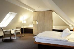 圣彼得奥尔丁Hotel Windschur的一间卧室配有一张床、一张书桌和一个窗户。