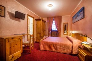 库马约尔德格拉斯尔酒店的一间卧室配有一张床、一张书桌和一个窗户。