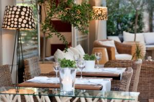 雅典海景酒店的庭院配有桌椅和酒杯