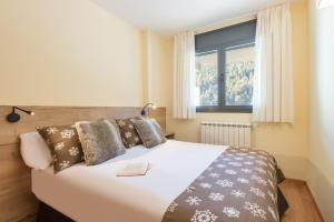 博尔德斯·代瓦里拉Pierre & Vacances Andorra Sunari Peretol的卧室配有一张大白色床和窗户