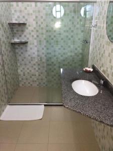 瓜皮米林Pousada Nascente Pequena的一间带水槽和玻璃淋浴的浴室