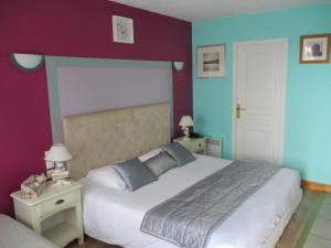 康村奥古斯丁酒店的一间卧室设有一张大床,拥有紫色和蓝色的墙壁