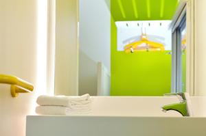 图尔图尔北F1酒店的浴室配有盥洗盆、镜子和毛巾