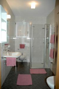 佩尔卡索恩贝格住宿公寓式酒店的浴室设有水槽和带粉红色垫的淋浴。