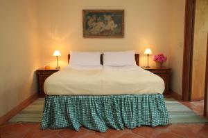 Serralunga di CreaTenuta Guazzaura的一张床位,房间配有两张桌子和两盏灯