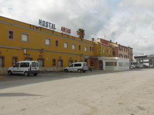 扎弗拉Hostal Arias的两辆白色货车停在黄色建筑前面