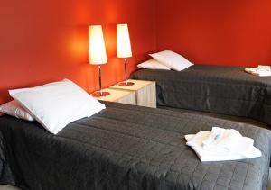 Kankaanpää卢米埃恩芬兰迪亚酒店的酒店客房设有两张床和红色的墙壁。