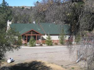 DescansoOakzanita Springs Camping Resort Cottage 4的一座带绿色屋顶和庭院的房子