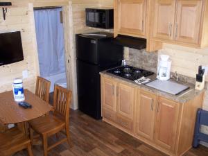 克罗弗戴尔Russian River Camping Resort Cottage 7的厨房配有黑色冰箱和桌椅