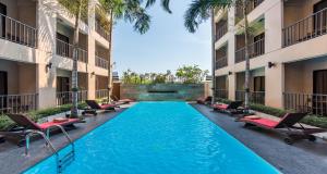莱卡邦素万那普村舍酒店的一座建筑物中央的游泳池