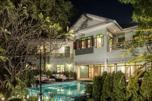 曼谷曼谷拉威坎拉亚酒店的夜间带游泳池的别墅