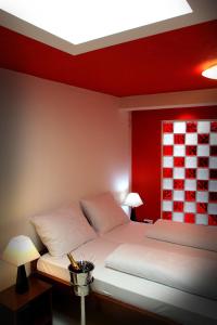 比奥格勒·纳·莫鲁卡尔皮摩尔酒店的卧室配有白色的床铺和红色的墙壁