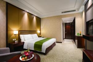 顺义北京临空假日酒店的酒店客房设有一张大床和一张桌子。