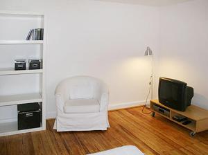 汉堡汉堡西区公寓的客厅配有白色椅子和电视